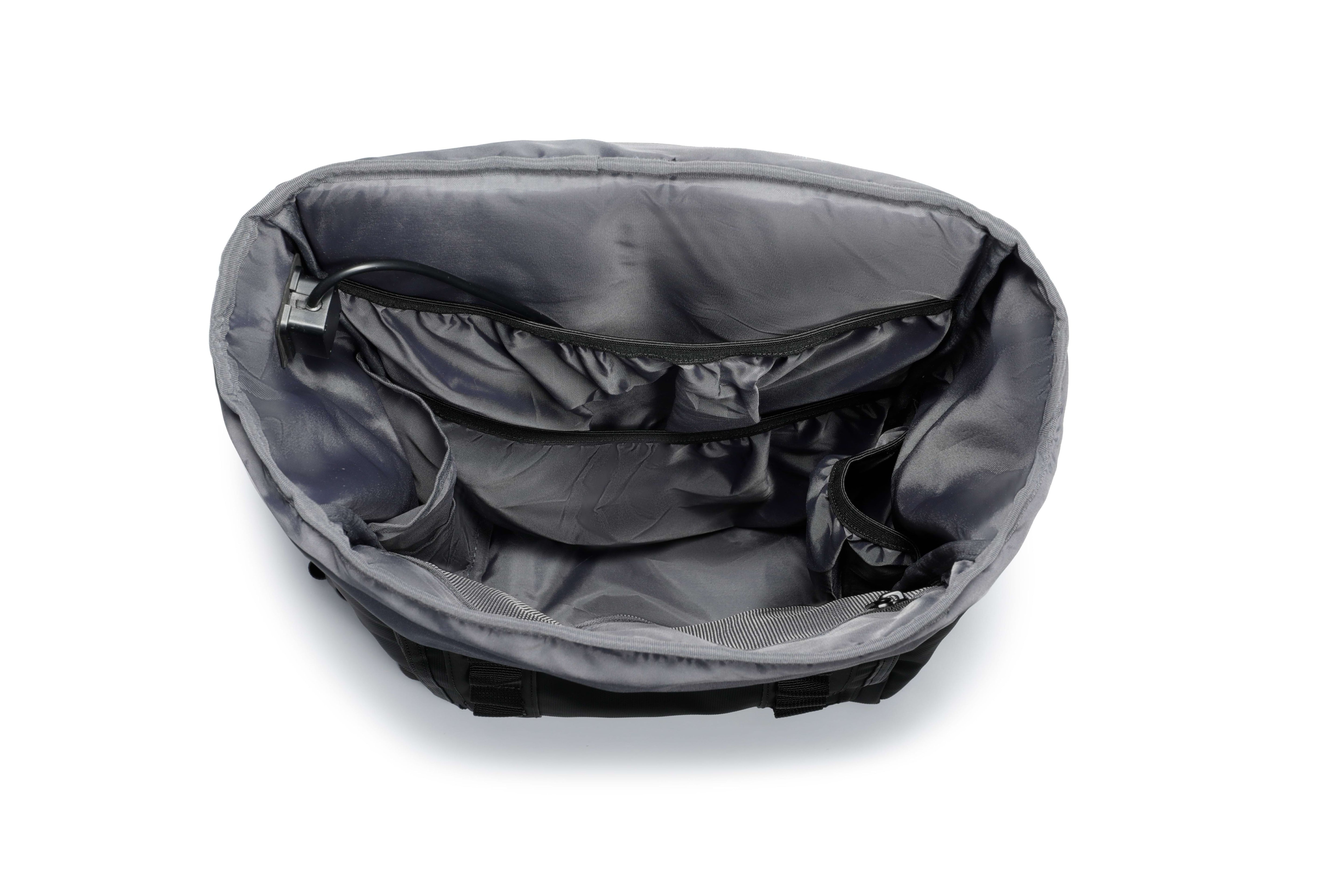 Matte Black TideTrail internal compartments including side pockets, secured zipper mesh pocket. Also shown is the USB cable for power bank connectivity